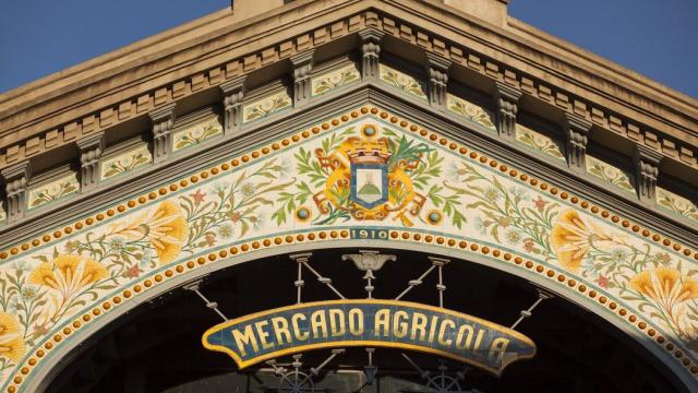 Foto de la fachada donde se destaca el trabajo de mayolica en los azulejos y la cartelería adornada con el nombre de Mercado Agrícola